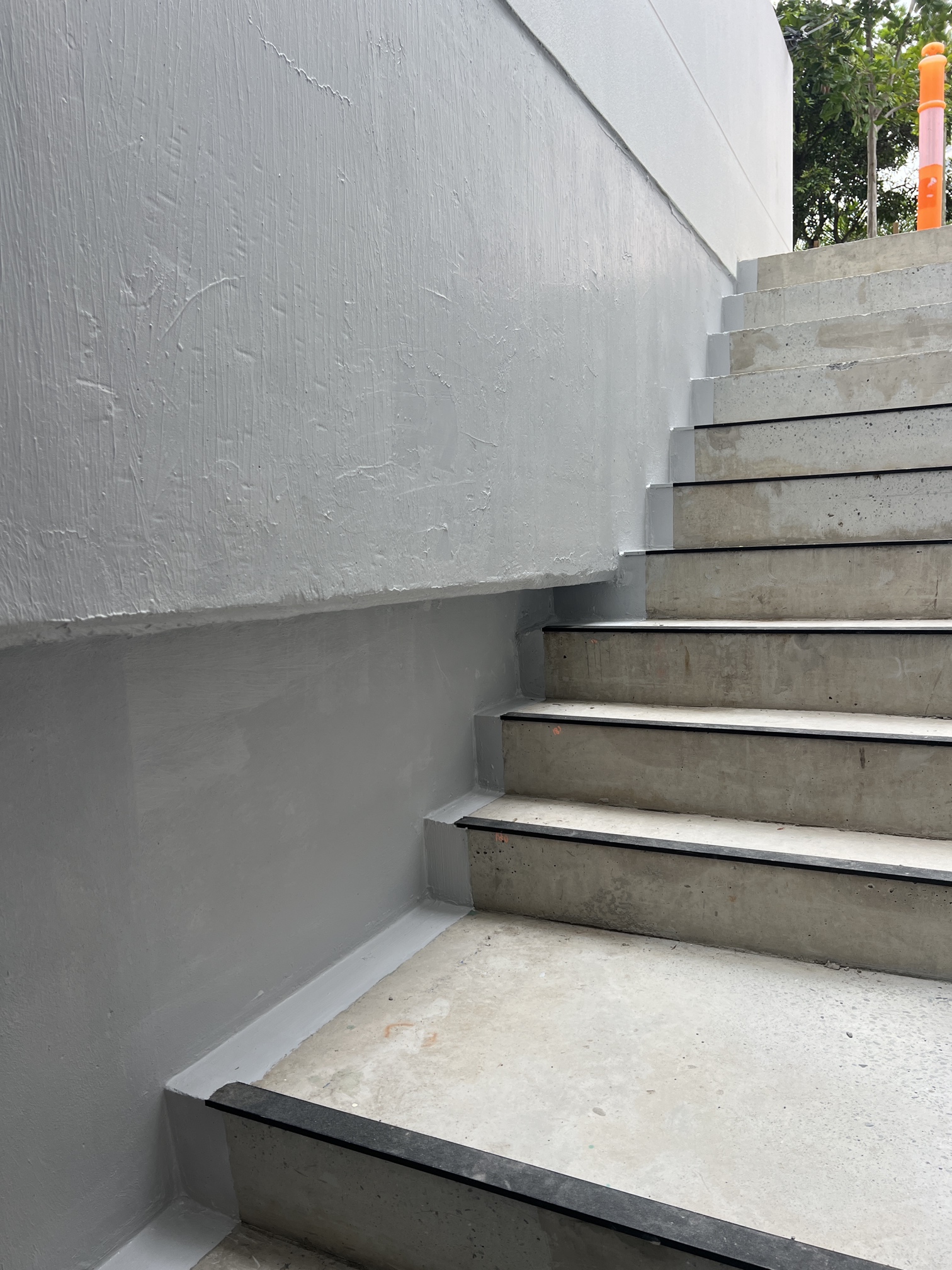 External Steps, angle from bottom of steps upwards. Stair Core with Water Ingress Issues Addressed no longer leaking into adjacent walls. Can see light membrane running along on edge of steps